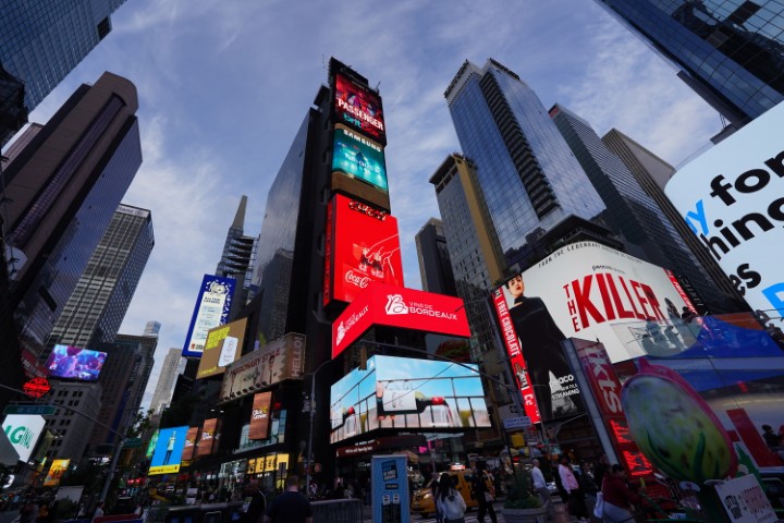 Some of the tall buildings of Times Square, partly covered with giant screens running adverts.